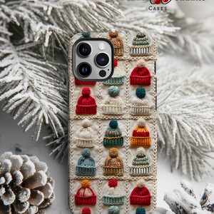 Könnte beinhalten: Eine Handyhülle mit einem Muster aus bunten Strickmützen. Die Hülle ist für ein iPhone mit einer Kamerabuckel konzipiert. Die Hülle ist weiß mit einer dezenten Textur.