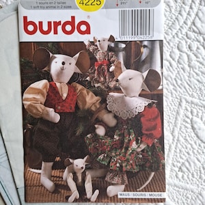 Könnte beinhalten: Ein Burda Schnittmusterumschlag 4225 für ein Stofftier-Maus in zwei Größen, 55 cm und 25 cm. Das Cover zeigt drei Stoffmäuse in festlicher Kleidung, darunter eine Weste, ein Rüschenkleid mit Spitzenkragen und ein kleines Outfit für die kleine Maus.