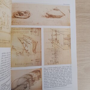May include: A black and white illustration of a medieval siege weapon. The weapon is a large, wheeled platform with a long, pointed arm that can be raised and lowered. The arm is attached to a large, circular wheel that is powered by a system of gears and levers. The weapon is designed to launch projectiles at enemy fortifications.