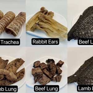 May include: Assortment of dried pet treats, including beef trachea, rabbit ears, beef liver, lamb lung, beef lung, and lamb liver. Each treat is displayed on a white plate with a black text label.