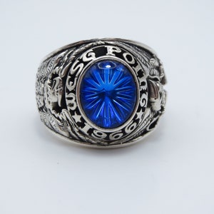 Peut inclure: Une bague en argent avec une pierre bleue et l'inscription "USMC 1966" autour de la pierre.
