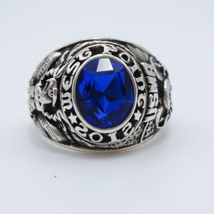 Peut inclure: Une bague en argent avec une pierre précieuse bleue et l'inscription "USMC 1969" autour de la pierre.