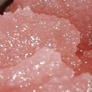 Könnte beinhalten: Nahaufnahme einer rosa, glitzernden Substanz mit einer glatten, strukturierten Oberfläche.