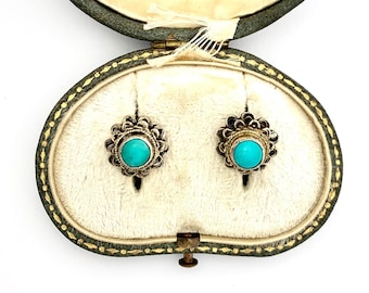 Könnte beinhalten: Ein Paar türkisfarbene Ohrringe mit silbernen Fassungen in einer grünen Samt-Schmuckschatulle. Die Schachtel trägt ein Etikett mit der Aufschrift "Goldsmith & Silversmith London".