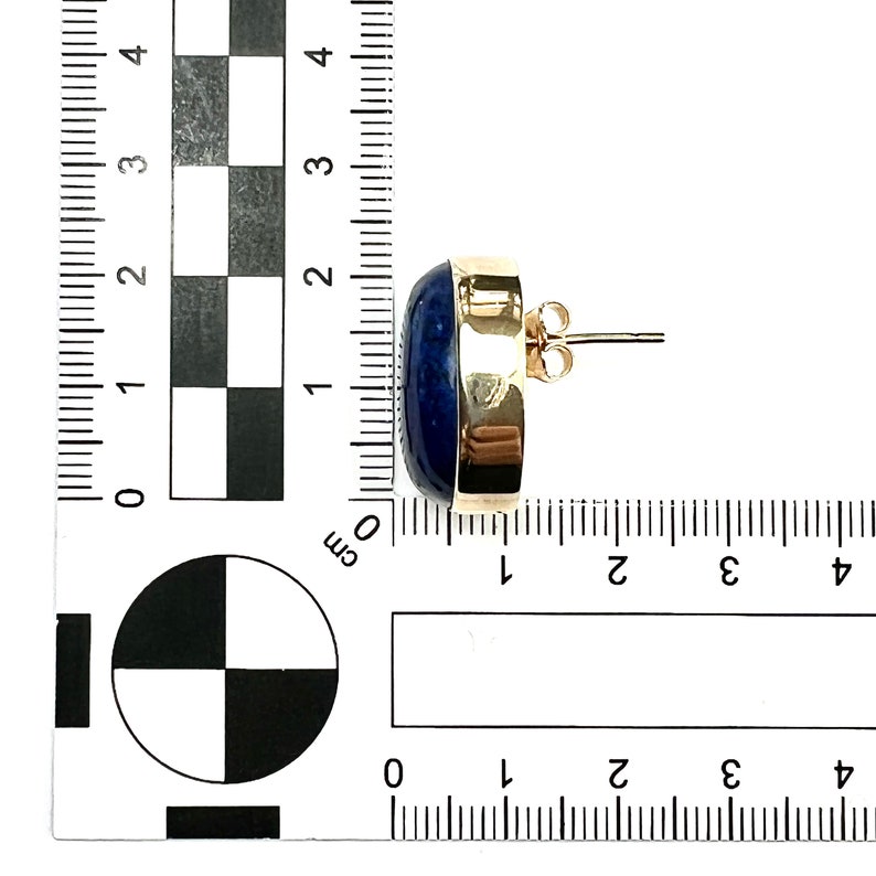 K&ouml;nnte beinhalten: Goldfarbene Ohrstecker mit einem blauen ovalen Edelstein. Die Ohrringe haben einen Durchmesser von etwa 1 cm.