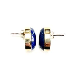 K&ouml;nnte beinhalten: Ein Paar goldene Ohrringe mit blauen Lapislazuli-Steinen. Die Steine sind in einer goldenen Fassung gefasst und die Ohrringe haben einen Stift und einen Schmetterlingsverschluss.