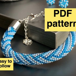 May include: A blue and silver beaded bracelet with a silver clasp. The bracelet is on a black surface. The text "PDF pattern" and "Easy to follow" is on the image.