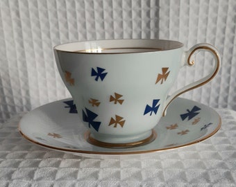 May include: A blue and gold teacup and saucer set with a delicate floral pattern. The cup and saucer are both trimmed with a gold band.