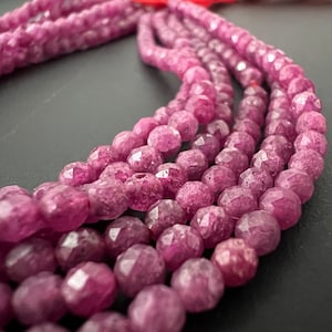 Peut inclure: Un brin de perles de pierres précieuses facettées roses. Les perles sont rondes et ont une forme légèrement irrégulière. Les perles sont enfilées sur un fil transparent.