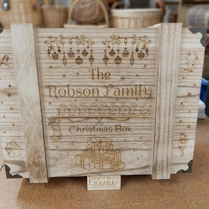 Könnte beinhalten: Eine hölzerne Weihnachtsbox mit einer personalisierten Inschrift, die "The Robson Family Christmas Box" lautet. Die Box ist mit einem festlichen Design aus Ornamenten, Schneeflocken und Elfen verziert. Die Box wurde von Derwent Valley Engravers hergestellt.