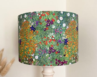 May include: A white lamp with a green lampshade featuring a floral print. The lampshade has a pattern of colorful flowers and leaves.