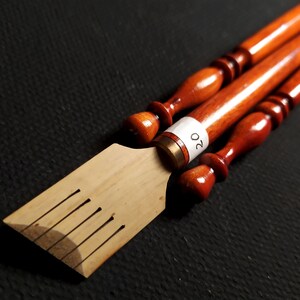 May include: A set of three wooden calligraphy nib holders, one with a numbered label that says "20".