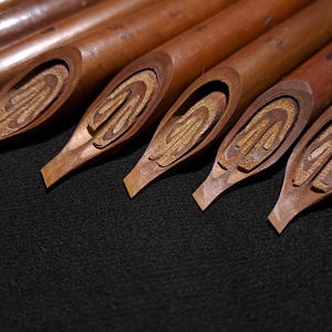 Artisan-crafted Handam Bili qalam set arranged upright with detailed traditional nib cuts.