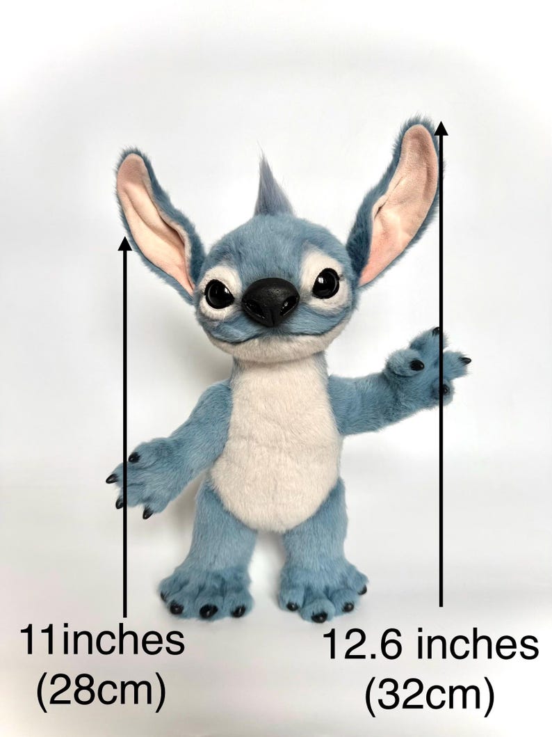 Puede incluir: Un mu&ntilde;eco de peluche azul de Stitch, de 28 cm de alto y 32 cm de ancho, con orejas grandes, un mech&oacute;n de pelo y vientre blanco. El mu&ntilde;eco tiene ojos negros, nariz negra y garras negras. El mu&ntilde;eco est&aacute; sobre un fondo blanco.