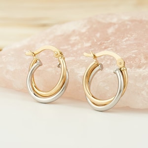 Two interlocking earrings which is color is white gold and yellow gold with latch back closure.