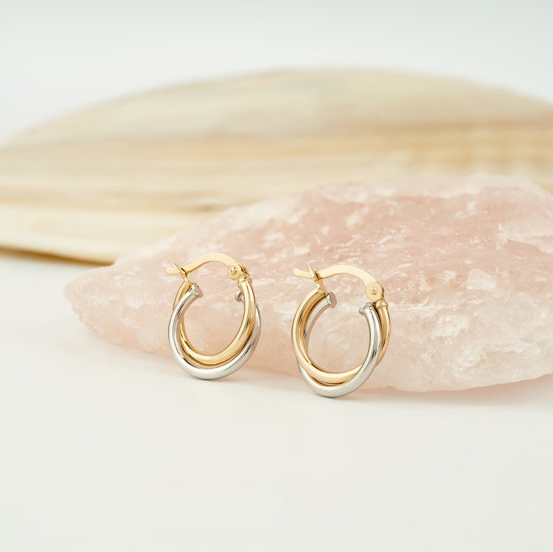 Two interlocking earrings which is color is white gold and yellow gold with latch back closure.