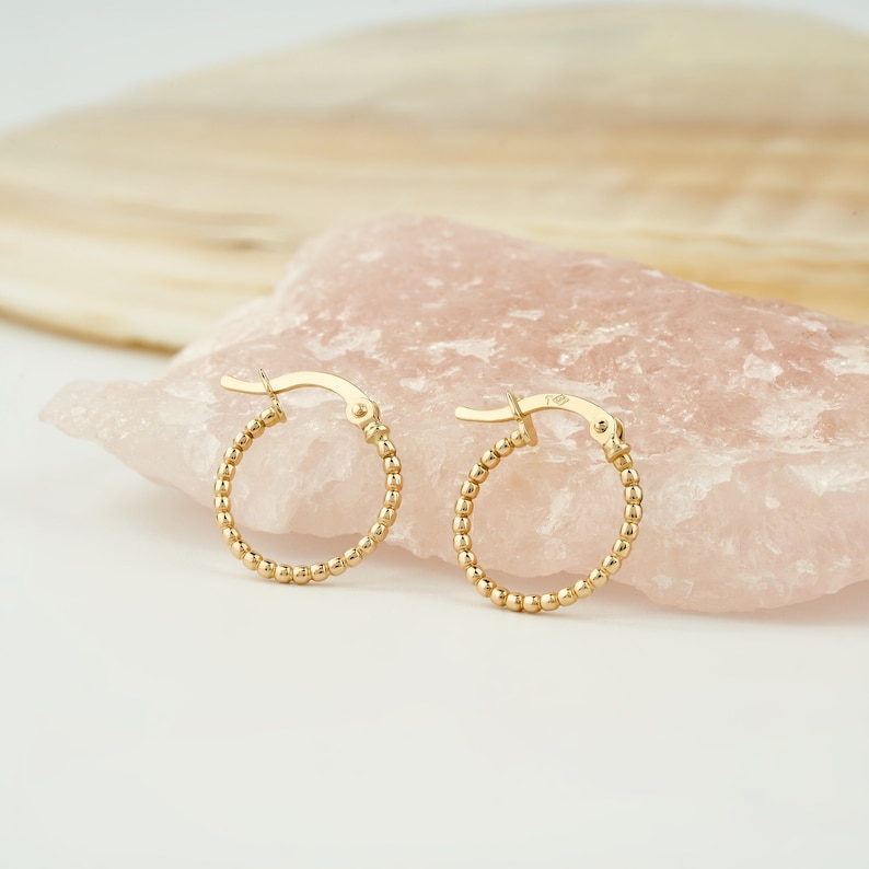 Embrace elegance with our 14K Yellow Gold Beaded Hoop Earrings. Delicate and dainty, these Tiny Bead Huggies are the epitome of Gold Minimalist Earrings. Dainty 14K Gold Hoops designed for women who appreciate timeless beauty.