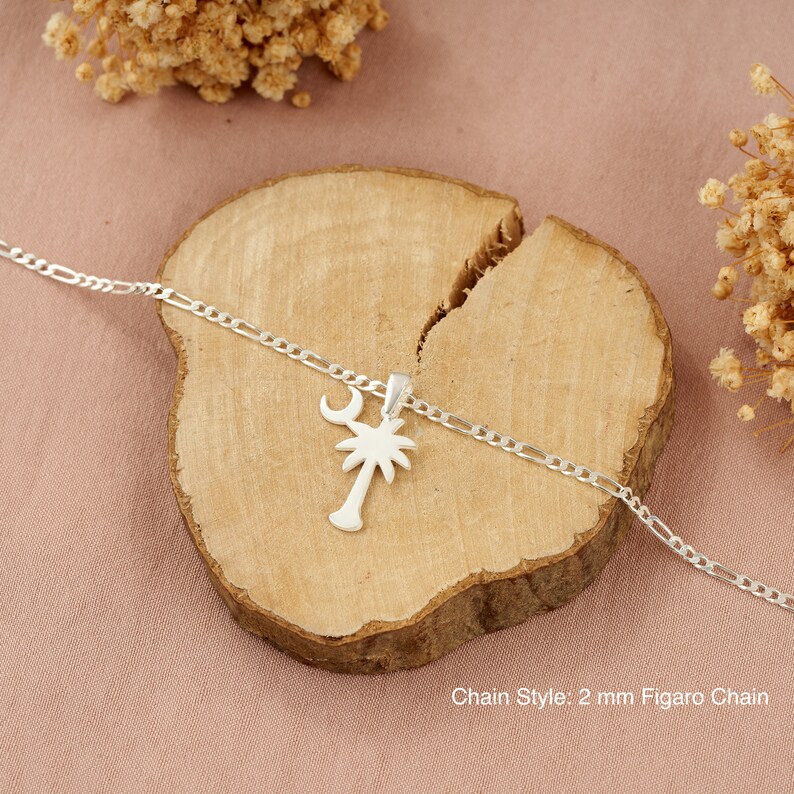 Op de afbeelding: Zilveren ketting met een palmboom hanger en een halve maan. De ketting is een 2 mm Figaro ketting.
