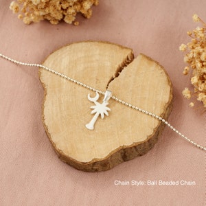Op de afbeelding: Zilveren ketting met een palmboom hanger en een halve maan bedel. De ketting is een bal kralen ketting. Kettingstijl: Bal kralen ketting