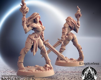May include: A light brown figurine of a female warrior holding a flaming torch and a sword. The warrior is wearing armor and boots. A second figurine of the warrior is visible from the back. The base of the figurine has a skull and the text "Kingdomless Figurines".