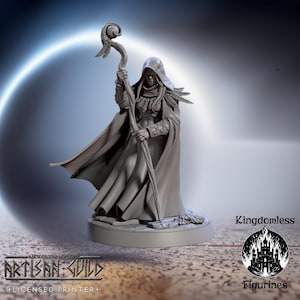 May include: A gray figurine of a robed figure holding a staff, with a hooded cloak and detailed armor. The figurine is on a circular base. The text "Kingdomless" and "Figurines" are visible. The Artisan Guild logo is also present.