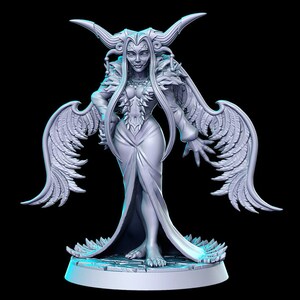 Puede incluir: Una figura blanca detallada de una figura femenina con cuernos, alas y un vestido fluido. La figura tiene una expresi&oacute;n severa y est&aacute; de pie sobre una base circular.