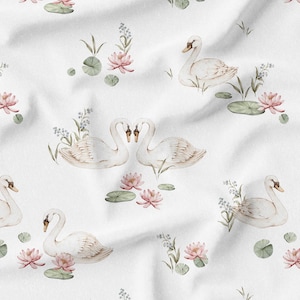 May include: White fabric with a repeating pattern of swans, pink lotus flowers, and lily pads. The swans are depicted in a watercolor style, with soft, muted colors. The overall design has a delicate, romantic feel.