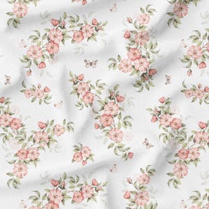 May include: White fabric with a repeating pattern of pink flowers, green leaves, and small butterflies. The floral design is arranged in a delicate, watercolor style, creating a soft and romantic aesthetic. The fabric has a slightly wrinkled texture.