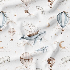 May include: Watercolor pattern featuring hot air balloons, whales, polar bears, moons, and stars in soft blue, brown, and gold tones. The design is set against a white background with a dreamy, whimsical aesthetic, suitable for children's decor.