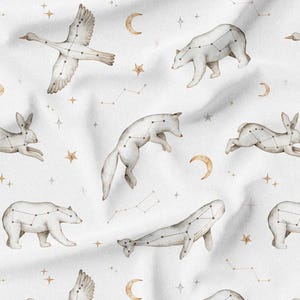 May include: White fabric with a repeating pattern of watercolor animals, including a bear, goose, fox, rabbit, and whale. Each animal is depicted with constellation lines. The design also features gold stars and crescent moons.