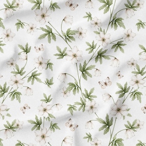 May include: White fabric with a repeating pattern of delicate white flowers, green leaves, and small butterflies. The floral design has a watercolor style, creating a soft and elegant aesthetic. The fabric is likely used for crafting or home decor.