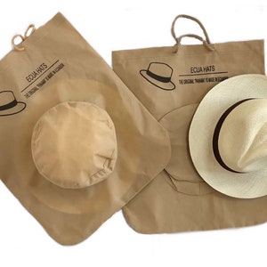 May include: Two brown paper bags with handles, each with a hat inside. The bags have the text "ECUA HATS" and "THE ORIGINAL PANAMA IS MADE IN ECUADOR" printed on them.