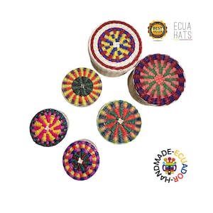 Può includere: Una collezione di cappelli colorati e intrecciati di varie dimensioni. I cappelli presentano motivi intricati in rosso, giallo, verde e blu. I cappelli sono fatti a mano in Ecuador, come indicato dal testo e dal logo.