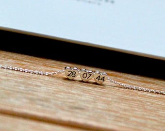 May include: Silver heart charm necklace with the numbers 28 07 44 engraved on the charms.