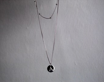 May include: A silver chain necklace with a silver pendant featuring the letter "A".