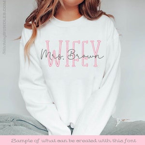 May include: White sweatshirt with the text "WIFEY" in pink outlined letters and "Mrs. Brown" in cursive script below.