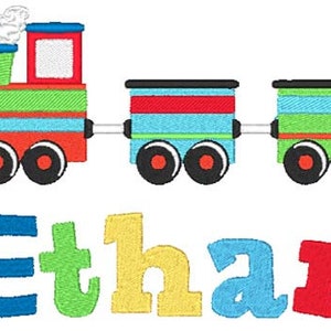 Pu&ograve; includere: Un treno ricamato colorato con tre vagoni e il nome Ethan scritto in lettere colorate sotto. Il treno &egrave; rosso, verde, blu e giallo.