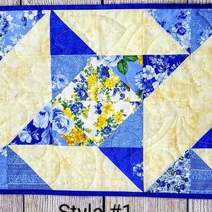 Puede incluir: Un camino de mesa acolchado con un patr&oacute;n floral azul y amarillo. El camino de mesa est&aacute; hecho de cuadrados y tri&aacute;ngulos, y el acolchado se realiza en un patr&oacute;n de espiral. El texto "Style #1" es visible en la parte inferior de la imagen.