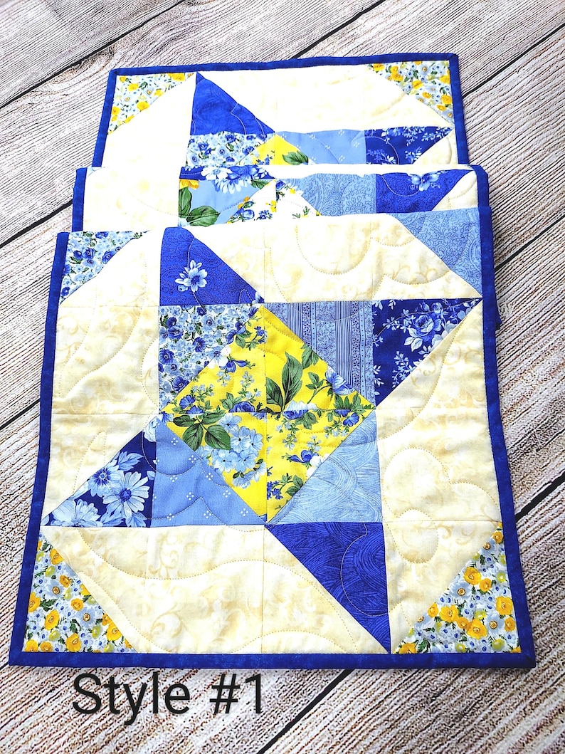 Puede incluir: Un camino de mesa acolchado con un patr&oacute;n floral azul y amarillo. El camino de mesa est&aacute; hecho de cuadrados de tela cosidos juntos en un patr&oacute;n geom&eacute;trico. El camino de mesa tiene un borde azul y est&aacute; acolchado con un patr&oacute;n ondulado. El texto "Style #1" es visible en la imagen.
