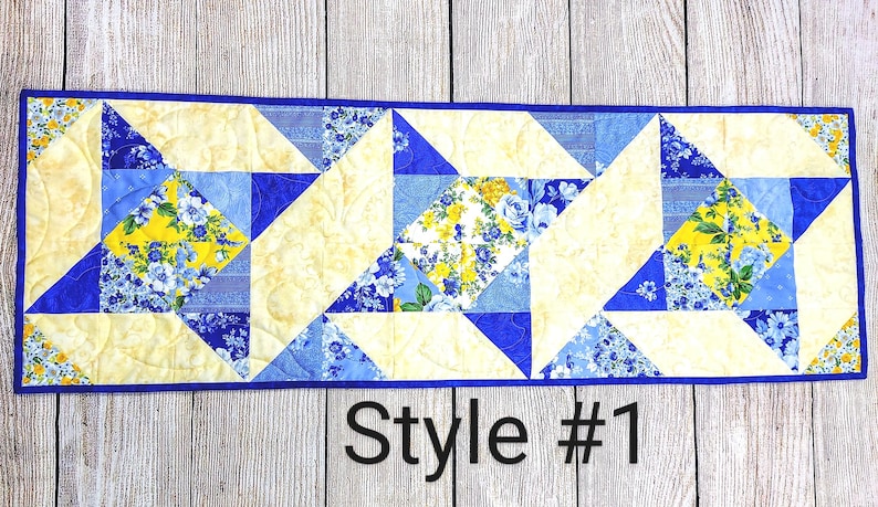 Puede incluir: Un camino de mesa acolchado azul y amarillo con un patr&oacute;n geom&eacute;trico. El camino de mesa est&aacute; hecho de tela con estampado floral. El texto "Style #1" es visible en la parte inferior de la imagen.