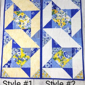 Puede incluir: Dos caminos de mesa con un patr&oacute;n floral azul, amarillo y blanco. Los caminos de mesa est&aacute;n hechos de tela y tienen un dise&ntilde;o acolchado. El camino de mesa de la izquierda tiene un fondo amarillo y el camino de mesa de la derecha tiene un fondo blanco. Los caminos de mesa est&aacute;n etiquetados como "Style #1" y "Style #2".