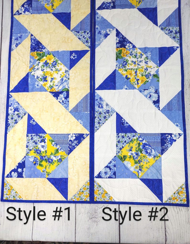 Puede incluir: Dos caminos de mesa con un patr&oacute;n floral azul, amarillo y blanco. Los caminos de mesa est&aacute;n hechos de tela y tienen un dise&ntilde;o acolchado. El camino de mesa de la izquierda tiene un fondo amarillo y el camino de mesa de la derecha tiene un fondo blanco. Los caminos de mesa est&aacute;n etiquetados como "Style #1" y "Style #2".