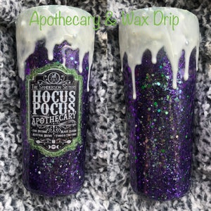 May include: A purple and green glitter tumbler with a white wax drip. The tumbler features a black and white label with the text "The Sanderson Sisters Hocus Pocus Apothecary Fine Potions Magic Elixirs Mystical Brews Tonics & Tinctures".