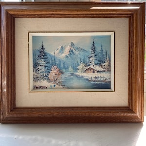 May include: A framed painting depicting a snowy mountain scene with a small cabin in the foreground. The painting is signed "P. Warden" in the bottom left corner.