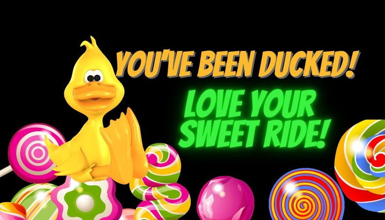 Puede incluir: Un pato de goma amarillo con una gran sonrisa se sienta sobre una pila de piruletas de colores. El texto "You've been ducked! Love your sweet ride!" est&aacute; escrito en una fuente de estilo c&oacute;mic.