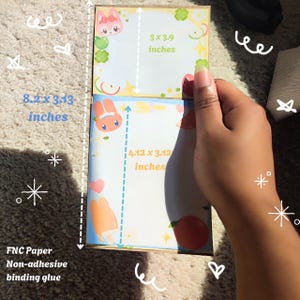May include: A stack of FNC Paper non-adhesive binding glue notebooks. The top notebook measures 3 x 3.9 inches, and the bottom notebook measures 4.12 x 3.12 inches. The stack is 8.2 x 3.13 inches. Each notebook has a cartoon design.