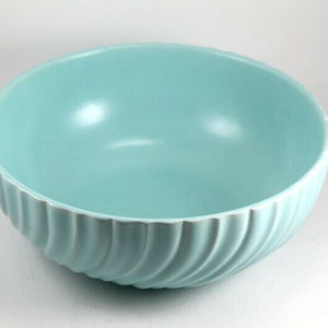May include: A light blue ceramic bowl with a wavy, ribbed design. The bowl is empty and has a glossy finish.