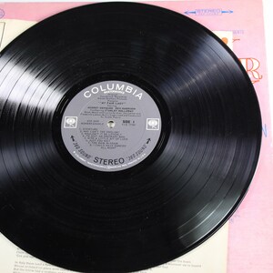 May include: A black vinyl record with a Columbia Records label. The label features the title "My Fair Lady" and the artist "Robert Goulet, Rex Harrison". The record is in a stereo format.