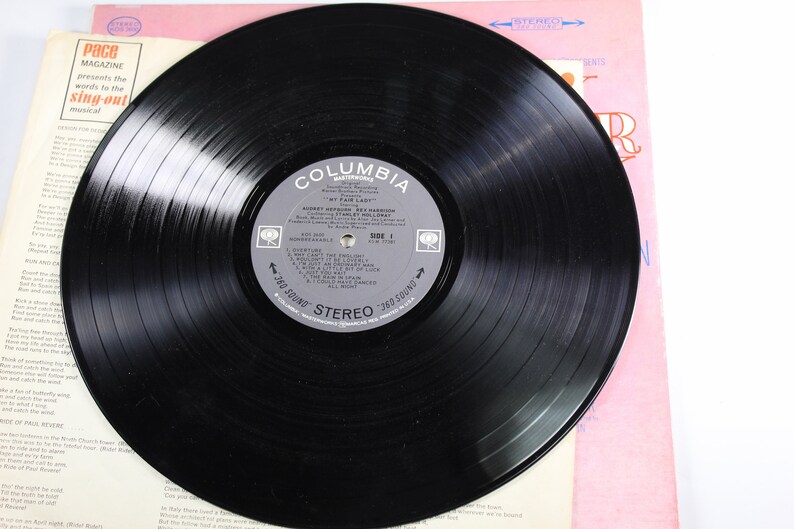 May include: A black vinyl record with a Columbia Records label. The label features the title "My Fair Lady" and the artist "Robert Goulet, Rex Harrison". The record is in a stereo format.