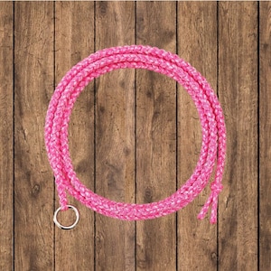 May include: Pink braided rope with a silver ring on a wooden background.